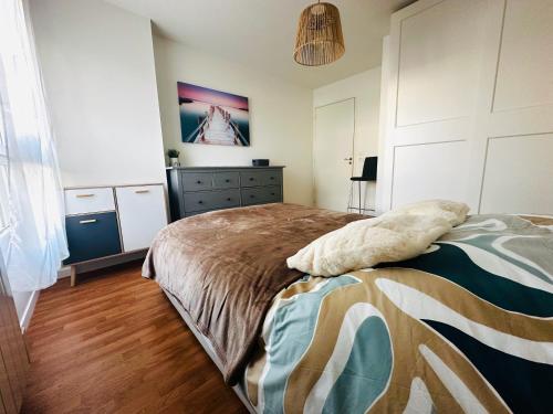 a bedroom with a bed and a dresser at Cocon urbain, appartement 4 personnes avec jardin à 2mn de Vannes, Golfe du Morbihan in Plescop