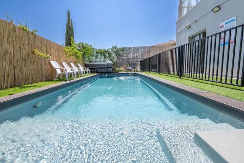 a swimming pool with two chairs and a fence at Villa siena - וילה מהממת עם בריכה פרטית מול הכנרת in Migdal