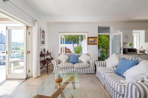a living room with two couches and a table at Amanzi on Thesen Island - Knysna in Knysna