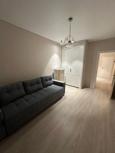 a living room with a black couch in a room at Tamarix in Almaty