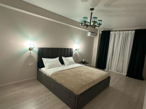 a bedroom with a large bed and a chandelier at Tamarix in Almaty