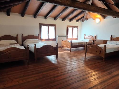 a room with four beds in a room with wooden floors at Isola della Cona - Riserva naturale Foce dell'Isonzo in Staranzano