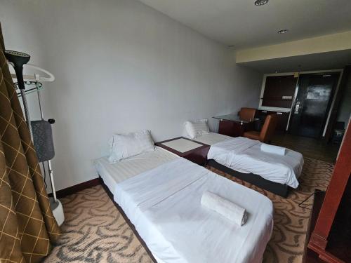 a hotel room with three beds in it at Kota Kinabalu City Ensuite at SCSP Ming Garden in Kota Kinabalu