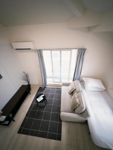 a bedroom with a couch and a large window at D Regalo in Ichikawa