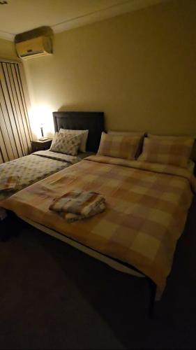 a bedroom with two beds with a blanket on it at Fun and spacious Room in Guildford