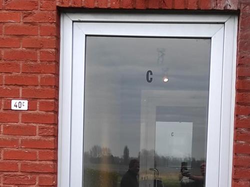 a reflection of a man in the window of a building at Home Oceane in Nieuwpoort