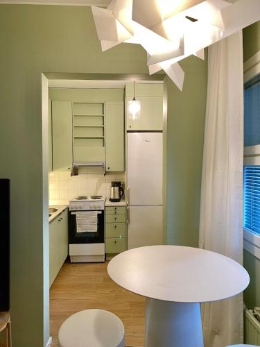 a kitchen with a white table and a white ceiling at Ellis Seaside Suite in Helsinki