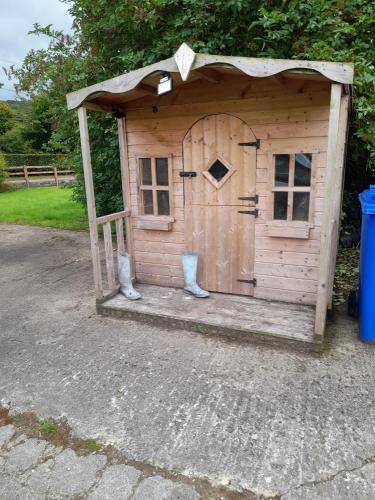 a small wooden out house with a door at 3 Bed Farmhouse - Sleeps 6 - Wifi - Parking in Omagh