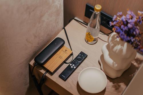 a table with a phone and a remote control on it at Eternity Athens -Opening 2025- in Athens