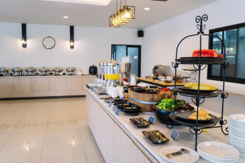 a buffet line with food on it in a restaurant at Shewin de Bangkok in Ban Bang Bamru