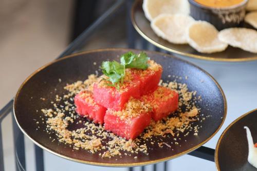 a plate of food with watermelon on a counter at Shewin de Bangkok in Ban Bang Bamru