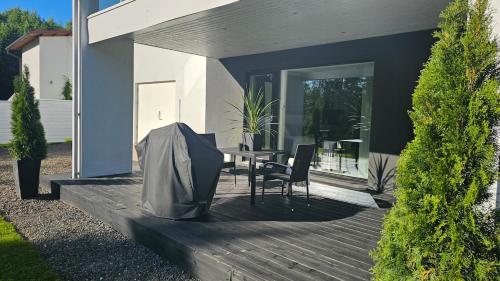 a wooden deck with a table and chairs on a house at Eco-friendly stay with hot tub & panorama view in Oulu