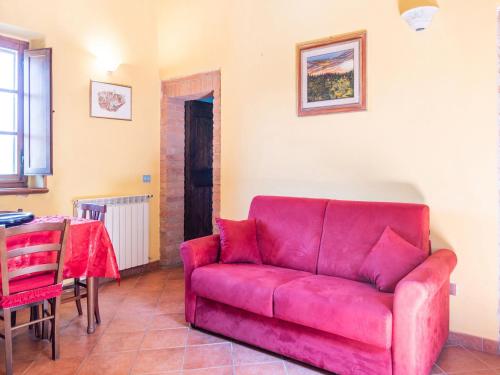 a red couch in a living room with a table at Sun-kissed holiday home in Monti di Sotto