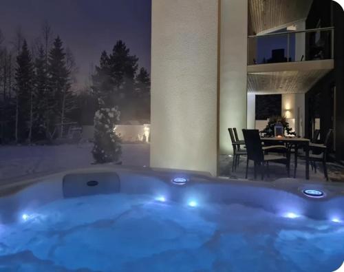 a jacuzzi tub in a room with a dining table at Eco-friendly stay with hot tub & panorama view in Oulu