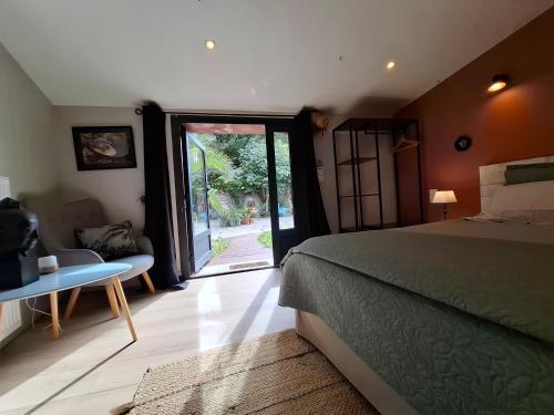 a bedroom with a bed and a sliding glass door at Shanti Home in La Tour-sur-Orb