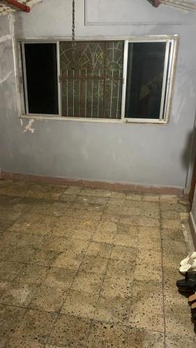 an empty room with two windows and a floor at Tripathi Villa in Murbād