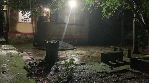 a fountain in the middle of a courtyard at night at Tripathi Villa in Murbād