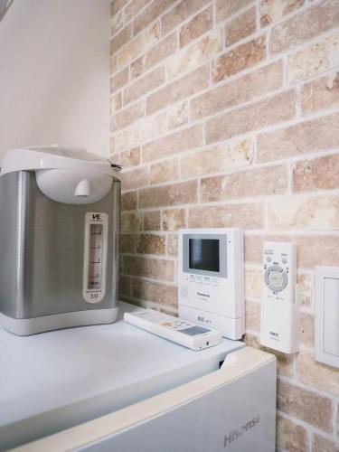 a computer on a counter next to a brick wall at D Regalo in Ichikawa