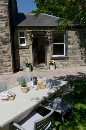 a table in front of a stone house with a table with bread at WM Apartments in Edinburgh