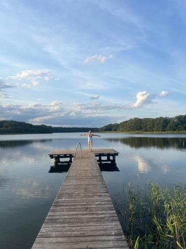 a person standing on a dock on a lake at Landhaus am See Flecken Zechlin in Rheinsberg