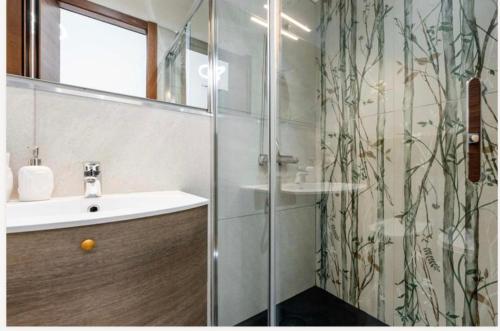 Un baño con ducha con lavabo y espejo. en Colombo House, en Quartu SantʼElena