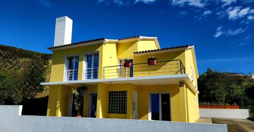 a yellow house with a white lighthouse on top of it at Villa Elysium in Ginetes