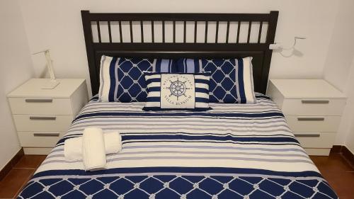 a bedroom with a bed with blue and white pillows at Villa Elysium in Ginetes