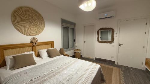 a bedroom with a large white bed and a door at Cozy 2BRs chalet in Einbay Boho designed in Ain Sokhna