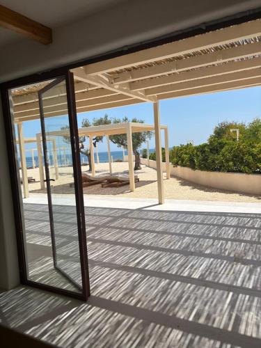 a view of the beach through a glass window at Villa Julia in Manfredonia