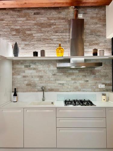 a white kitchen with a sink and a stove at Casa Baldi | Centro storico di Rimini in Rimini