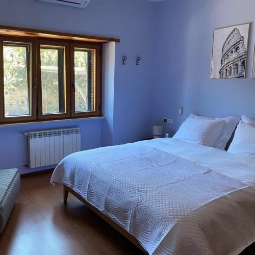 a bedroom with a large white bed with a window at Villa Valentina in Bracciano