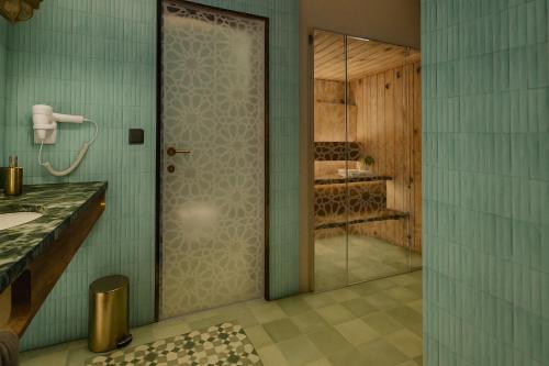 a bathroom with a shower and a glass door at Le Marrakech Boutique Hotel in Kleinblittersdorf
