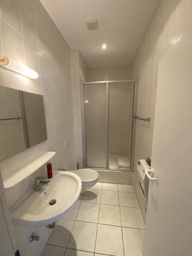 a white bathroom with a sink and a shower at Tower Lodge in Schönhagen