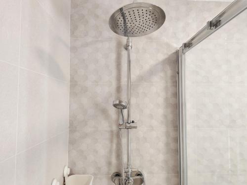 a shower with a shower head in a bathroom at Pes Na Area Fisterra 22 in Fisterra