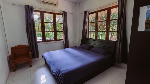 a bedroom with a bed and two windows at Kood Life in Ko Kood