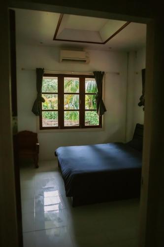 a bedroom with a bed and a window at Kood Life in Ko Kood
