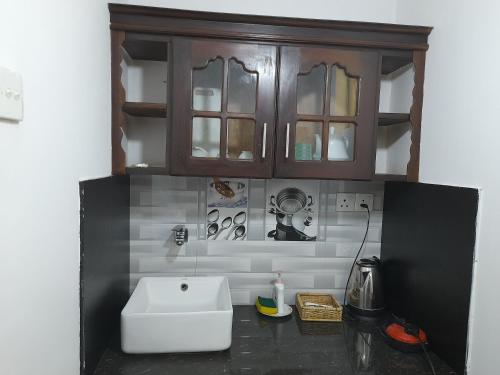 a kitchen with a white sink and a cabinet at Ging View Villa in Galle