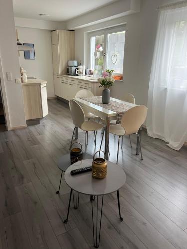 a living room with a table and chairs and a kitchen at Gemütliche Einliegerwohnung (2 Zimmer), Schönaich in Schönaich