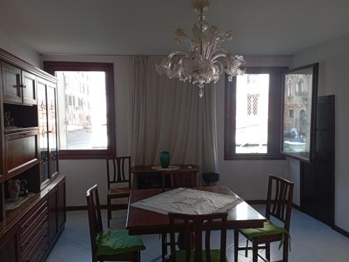 a dining room with a table and chairs and a chandelier at Venice Canal Spectacle in Venice