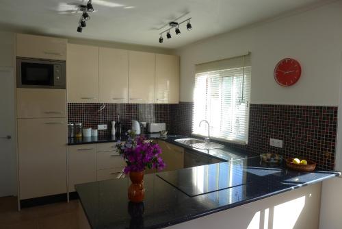 a kitchen with a counter with a clock on the wall at Casa Jamila in El Alquián