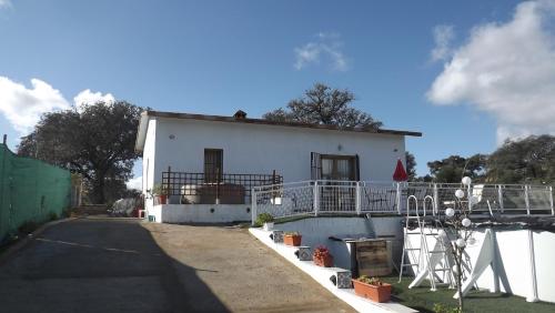 a white house with a fence around it at Villa Saudade, casa entre encinas in El Castillo de las Guardas