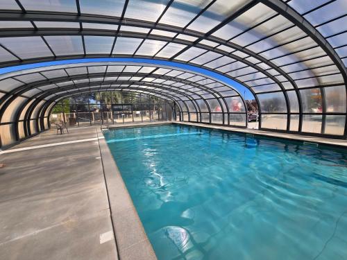 an indoor swimming pool with an arched ceiling at Mobil Home Cosy Plage à 50 m Camping 5 in Torreilles