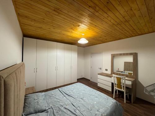 a bedroom with a bed and a desk and a mirror at Vila Curri in Kolgecaj