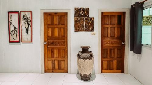 a vase sitting on the floor next to two doors at Kood Life in Ko Kood