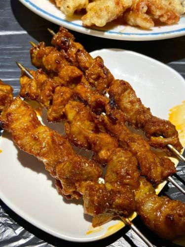 two plates of food on a table with meat on chopsticks at Snow Valley Ruixueju Boutique B&B in Huolonggou