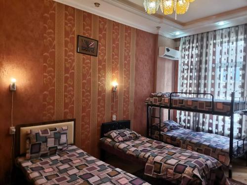 a room with two beds and a chandelier at Baku Hostel in Baku