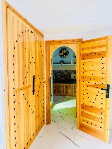 a room with two wooden doors and a doorway at Oualidia Holiday Apartment 5 in Oualidia