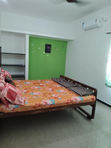 a bed in a room with a green wall at A Cozy Homestay in Coimbatore in Coimbatore