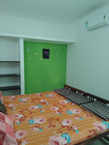 a bedroom with a bed with a floral blanket on it at A Cozy Homestay in Coimbatore in Coimbatore