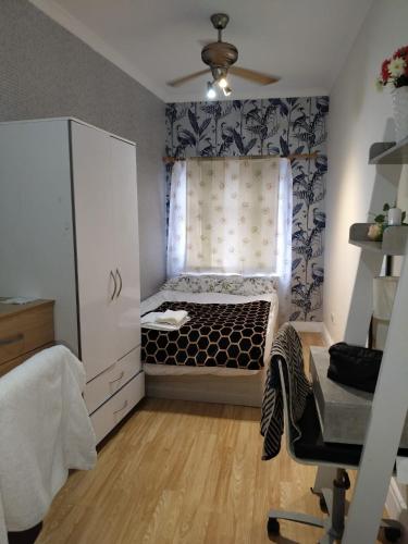 a small bedroom with a bed and a window at Panthea Home in Barkingside